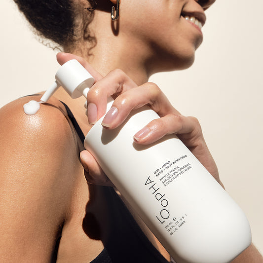 Person applying lotion cream to their shoulder with a bottle